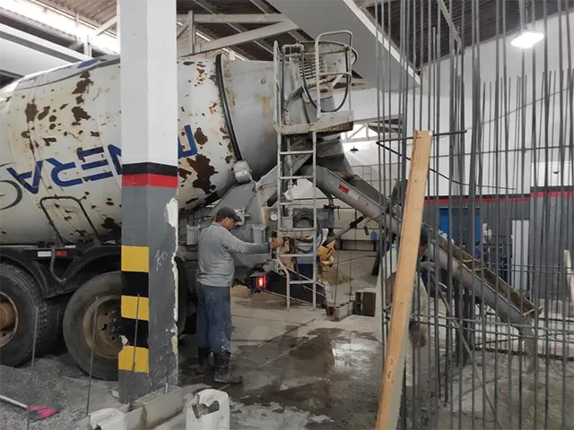 Caminhão despejando concreto: obra em transportadora